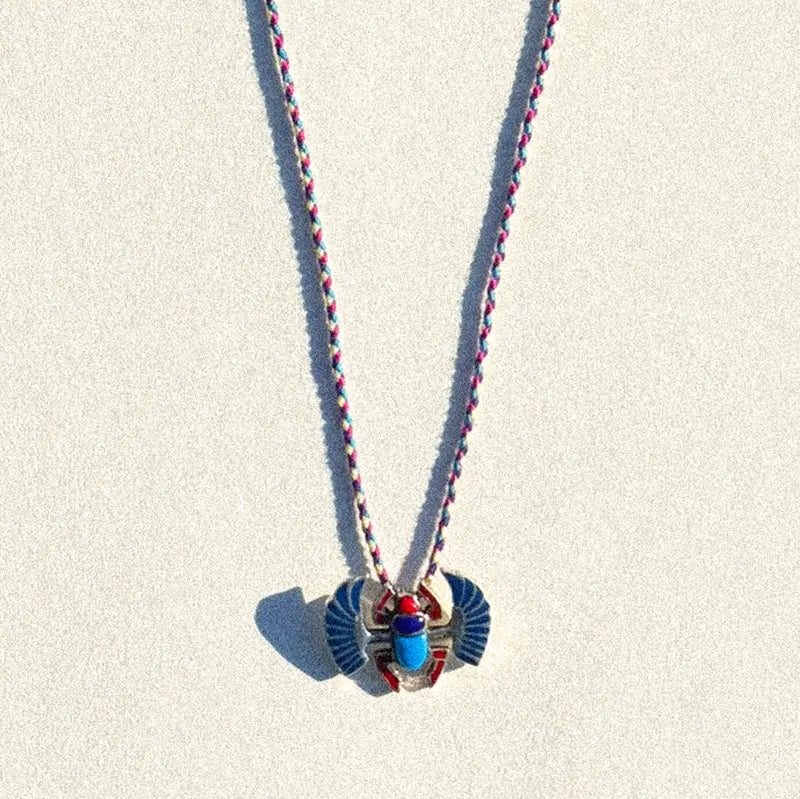 Charm Le Grand Scarabée Multicolore en argent présenté sur fond crème