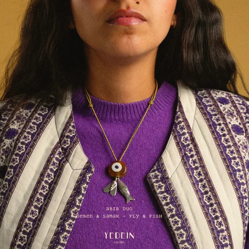 Collier Abir Solo avec un œil ambré et les charms Deben et Samak porté autour du cou