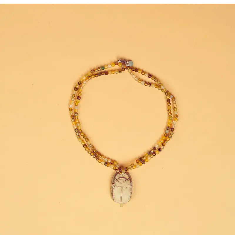 Collier artisanal égyptien Amal sur fond beige