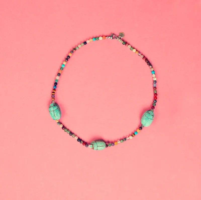 Collier Hayat artisanal sur fond rose vue de face