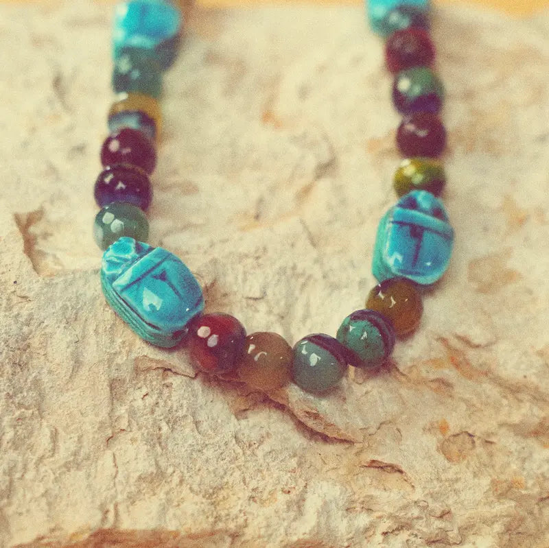 Collier Maya artisanal aux tons turquoise présenté sur une pierre