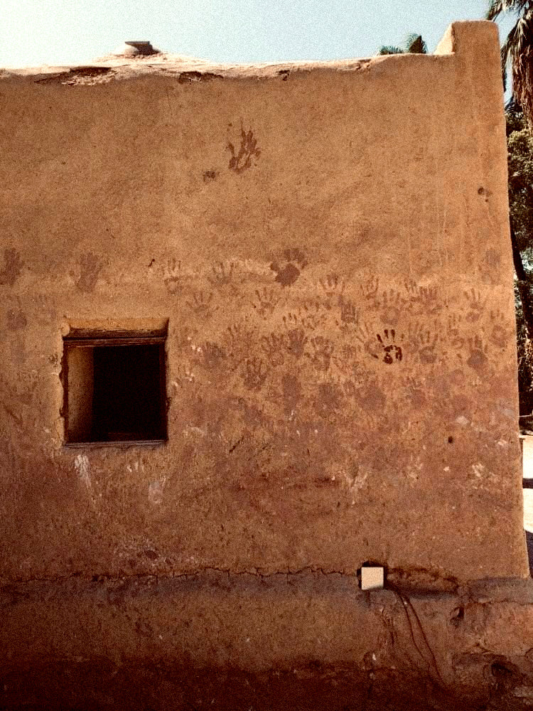 Mur d'une maison avec des empreintes de main, symbole de Yedein