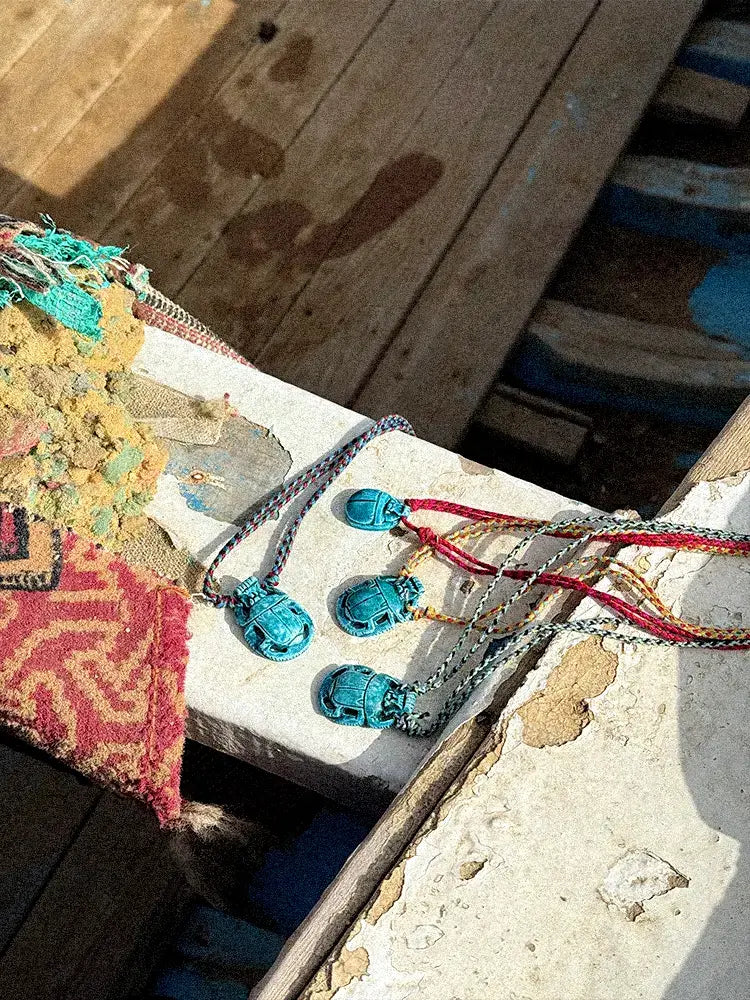 Quatre colliers Baba posés sur le rebord d'une barque