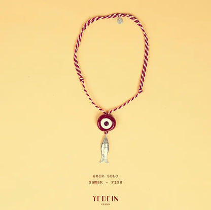 Collier Abir Solo avec un œil rouge rouille et un charm Samak sur fond beige