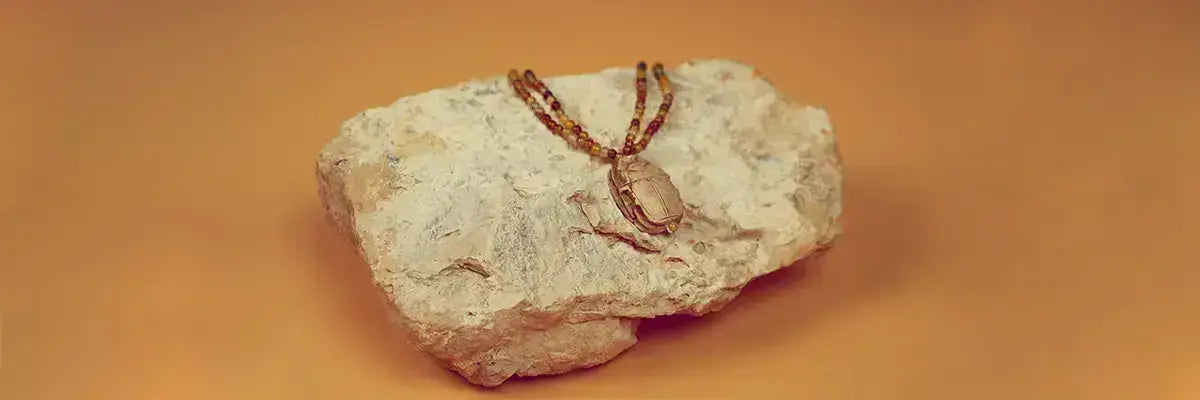 Collier Amal présenté sur une pierre pour représenter la collection scarabées