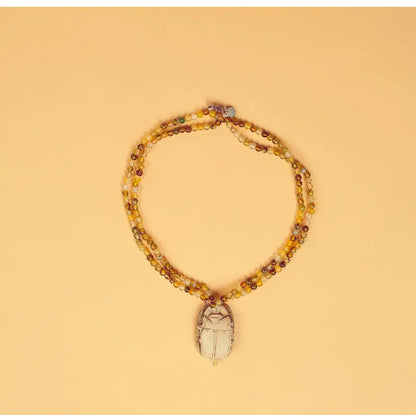 Collier artisanal égyptien Amal sur fond beige