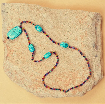Vue d'en haut du collier Haz en agate multicolore et scarabées turquoise