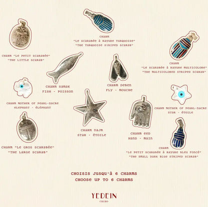 Les différents choix de charms sur fond crème pour le collier Abir Multicharms 