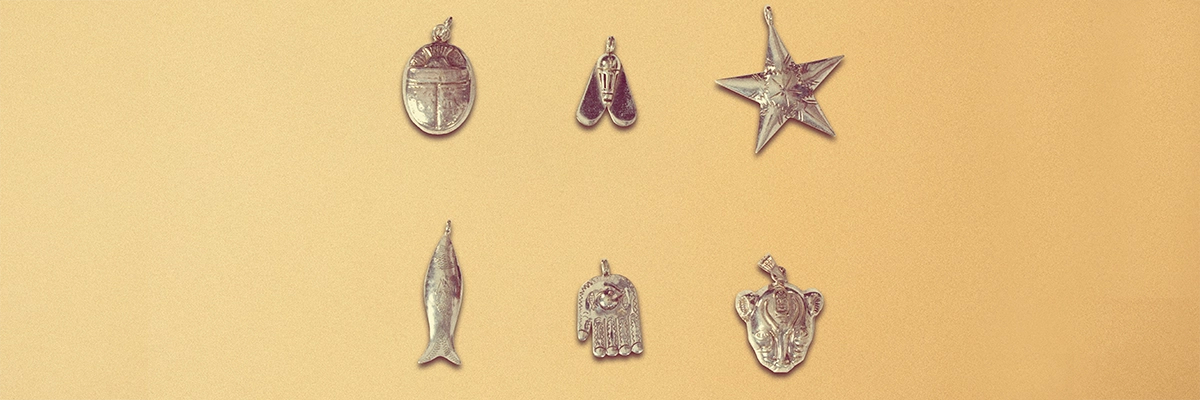Six charms en argents présentés sur fond beige